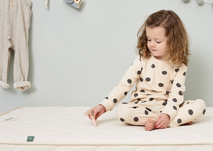 Little Green Sheep Natural Mattress - young girl sitting on bed